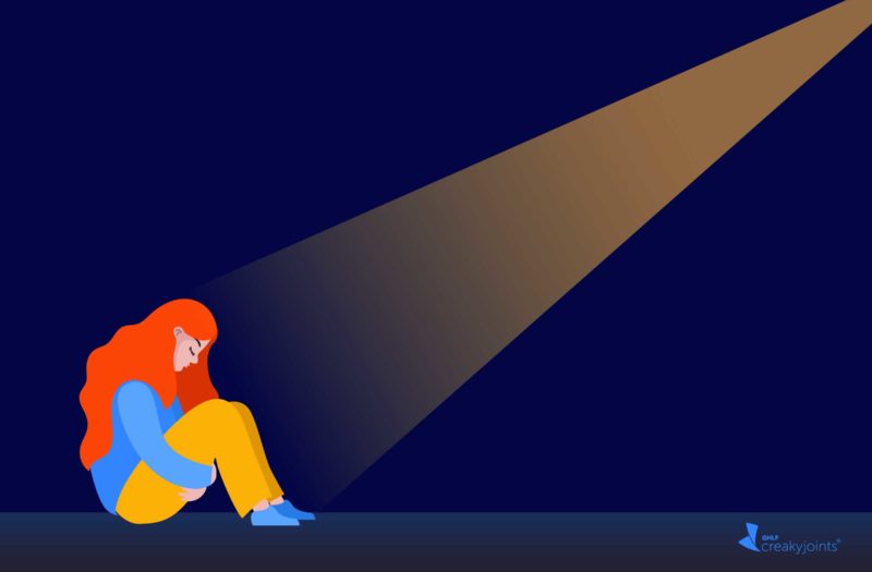 An illustration of a woman sitting on the floor of a dark room. She looks vulnerable, and there is a spotlight shining on her